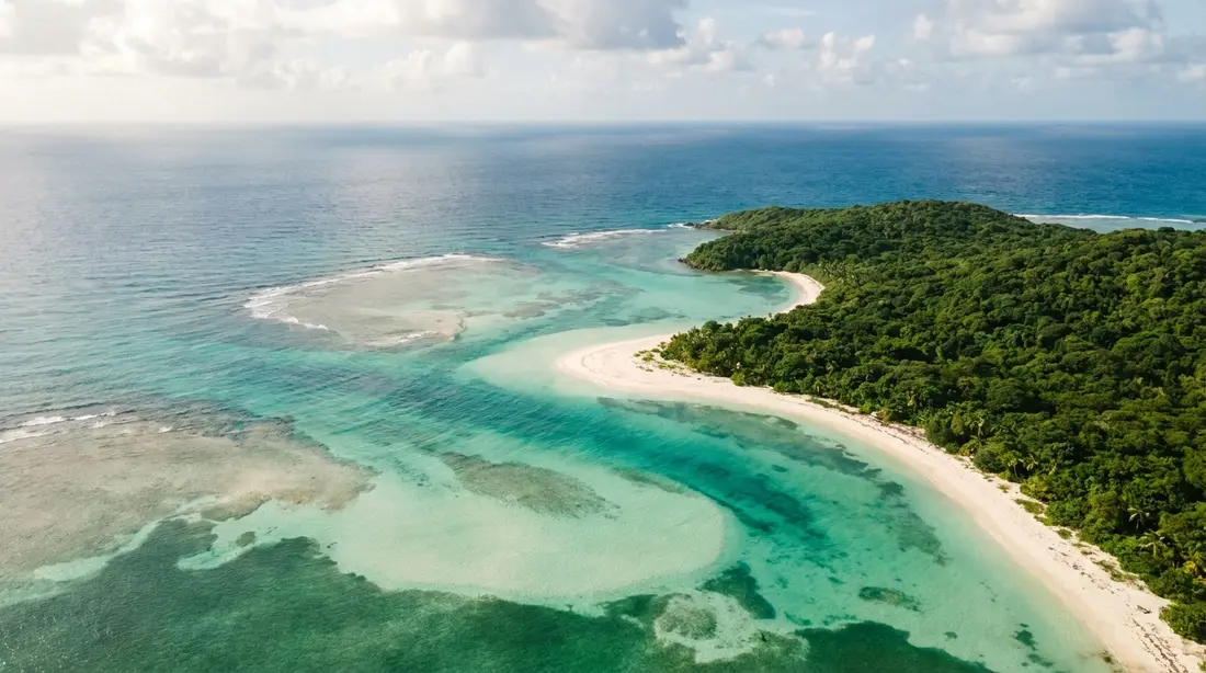 An aerial view of a turquoise Caribbean coastline and a white-sand beach