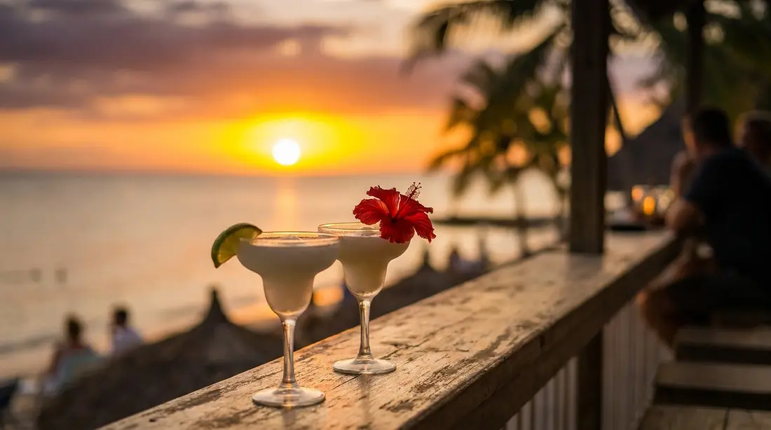 Tropical cocktails on a railing above the sea at sunset